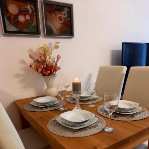 una mesa de comedor con una vela y platos y vasos en Apartament Green Park, en Starogard Gdański