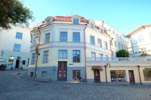 a large white building on a cobblestone street at Tallinn City Apartments - Old Town Townhouse in Tallinn