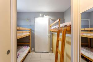 Zimmer mit 2 Etagenbetten und einer Tür in der Unterkunft Beau studio avec grande terrasse in La Grande-Motte