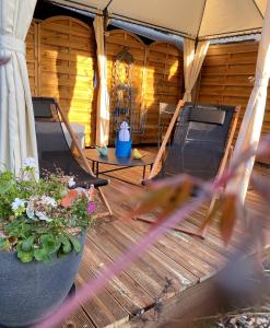 eine Terrasse mit 2 Betten und Blumen in einem Zelt in der Unterkunft Le Clos de la Barre in Basly