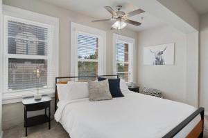 1 dormitorio con 1 cama, ventilador de techo y ventanas en Downtown Luxury Apartment with King Bed, en Waco