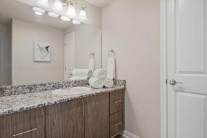 baño con lavabo y espejo grande en Downtown Luxury Apartment with King Bed, en Waco