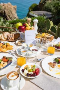 a table with many plates of food on it at Le Calette Bay in Cefalù
