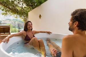 a man and a woman sitting in a bath tub at Le Calette Bay in Cefalù