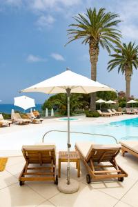 a pool with two lounge chairs and an umbrella at Le Calette Bay in Cefalù