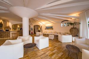a living room with white furniture and a bar at Le Calette Bay in Cefalù