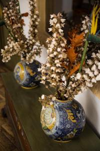 two vases with flowers in them on a table at Le Calette Bay in Cefalù