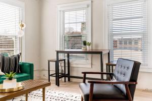 a living room with a table and chairs and windows at Chic Downtown Waco Apartment in Waco