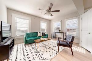 a living room with a green couch and a table at Chic Downtown Waco Apartment in Waco
