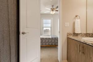 a bathroom with a sink and a ceiling fan at Chic Downtown Waco Apartment in Waco