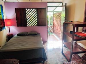 um quarto com uma cama, uma secretária e uma janela em Casitas La Playa em Puerto Viejo