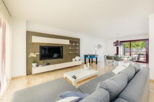 sala de estar con sofá gris y TV en Villa Puigverd, en Felanitx