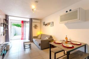 ein Wohnzimmer mit einem Tisch und einem Sofa in der Unterkunft Beau studio avec grande terrasse in La Grande-Motte