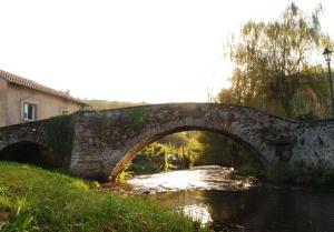 an old stone bridge over a river at Studio meublé Viane in Viane +3 photos