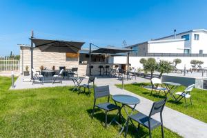 un patio con tavoli, sedie e ombrelloni di Antesia Coral Bay Resort by Ezoria Villas - Adults only a Coral Bay