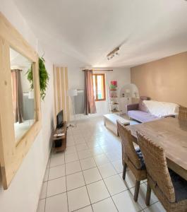 een woonkamer met een eettafel en een slaapkamer bij Maison le Sept de Céret in Céret
