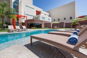 - une piscine avec 2 lits et un bâtiment dans l'établissement Gamma Colima Garden, à Colima