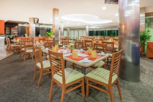 une salle à manger avec des tables et des chaises en bois dans l'établissement Gamma Colima Garden, à Colima