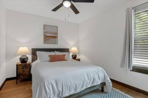 a white bedroom with a bed and a ceiling fan at The Duo A2 miles to Magnolia in Waco