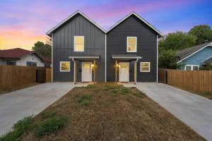 uma casa preta com uma entrada e uma cerca em The Duo A2 miles to Magnolia em Waco