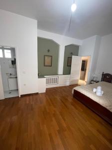 a large room with a bed and a wooden floor at Dr. J. Spon Apartment in Nafpaktos