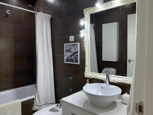 a bathroom with a sink and a mirror and a tub at Cozy LUXURY apartments*****. The city center in Valencia +13 photos