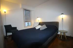 een slaapkamer met een bed, een stoel en een raam bij Midoon guest - The Balcony - Grand appartement Créteil proche Paris in Créteil