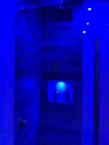 a blue bathroom with a shower with a blue light at B&B New Paris & Suite in Taranto +16 photos