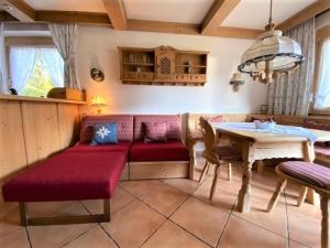 een woonkamer met een rode bank en een tafel bij Bergidyll 9 by Alpenidyll Apartments in Ramsau am Dachstein
