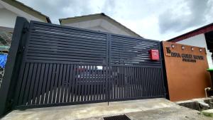 a black metal gate in front of a building at Eisya Guest House With Pool in Arau