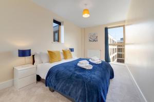 a bedroom with a bed with towels on it at Flourish Apartments - Mulberry House - Tottenham in London