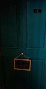 a blue wall with a sign hanging on it at À l'étape des randonneurs in Saignon