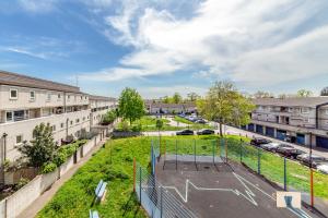 um complexo de apartamentos com um campo de basquetebol num parque de estacionamento em Flourish Apartments - Mulberry House - Tottenham em Londres