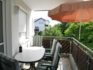 einen Tisch und Stühle auf einem Balkon mit Sonnenschirm in der Unterkunft Seepark Bansin,  App. 107 Haus 1, Benzmann in Bansin