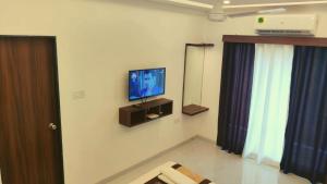 a living room with a tv on the wall at Rajdhani Resort Lonavala in Lonavala
