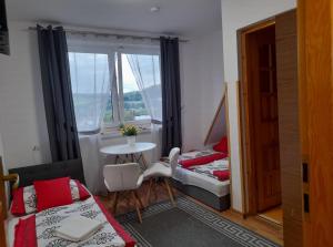 a room with two beds and a table and a window at Na Górce W Białym Dunajcu in Biały Dunajec