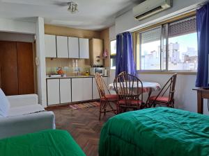 a living room with a table and chairs and a kitchen at Dpto El Cairo, tu lugar en Rosario in Rosario