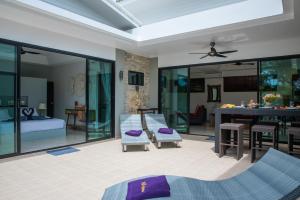 a living room with a bed and a dining room at Villa Anne in Lamai