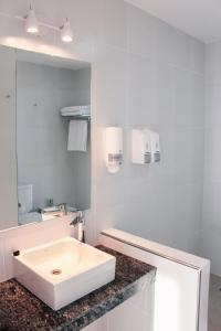 uma casa de banho branca com um lavatório e um espelho em CQ MITRE em Puerto Madryn