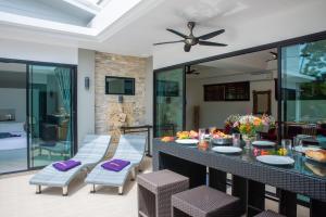 a patio with a table and chairs and a television at Villa Anne in Lamai