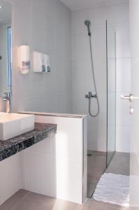 a white bathroom with a sink and a shower at CQ MITRE in Puerto Madryn