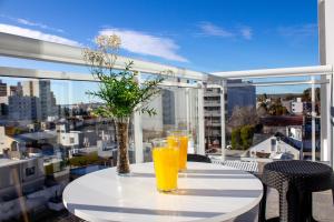 een tafel met 2 glazen sinaasappelsap op een balkon bij CQ MITRE in Puerto Madryn