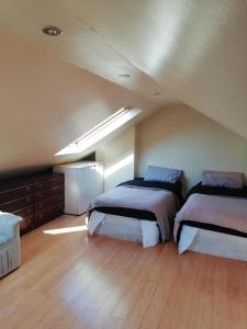 Christchurch Guesthouse Apartments في Harrow Wealt: غرفة نوم بسريرين في العلية