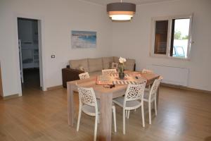 a dining room table and chairs in a living room at Villa del Principe in Carini