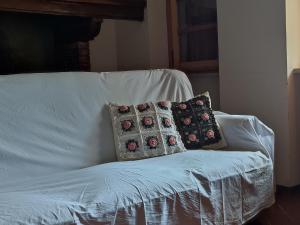 Un sofá blanco con dos almohadas. en Bed and Breakfast Country Hill, en Arezzo