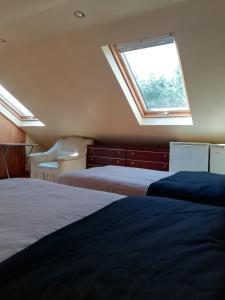 1 dormitorio con 2 camas y ventana en Christchurch Guesthouse Apartments, en Harrow Weald