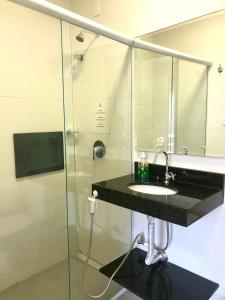 a bathroom with a sink and a shower at Pousada Crisana in Florianópolis