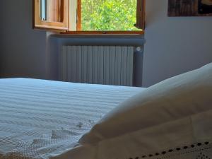 a close up of a bed with a window at Bed and Breakfast Country Hill in Arezzo