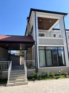 a house with a porch and stairs in front of it at Qabala Lux Villa in Gabala
