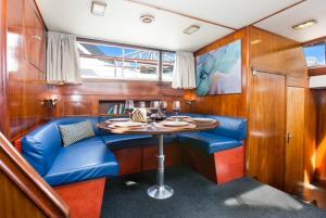 une salle à manger avec une table et des sièges bleus dans un bateau dans l'établissement Charming Boat in Barcelona - Perfect getaway, à Barcelone
